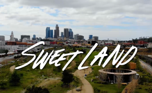 Sweet Land hand-lettering over set design at LA State Historic Park with Downtown Los Angeles skyline in the distance