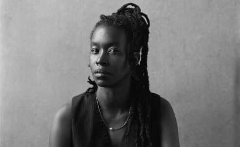 black and white portrait of an african american woman with braids looking into the camera